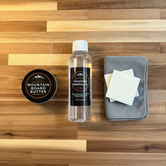 JMMS Mountain Care Kit Small — mineral oil bottle, board butter tin, square applicator pads, and grey microfiber cloth on natural wood surface