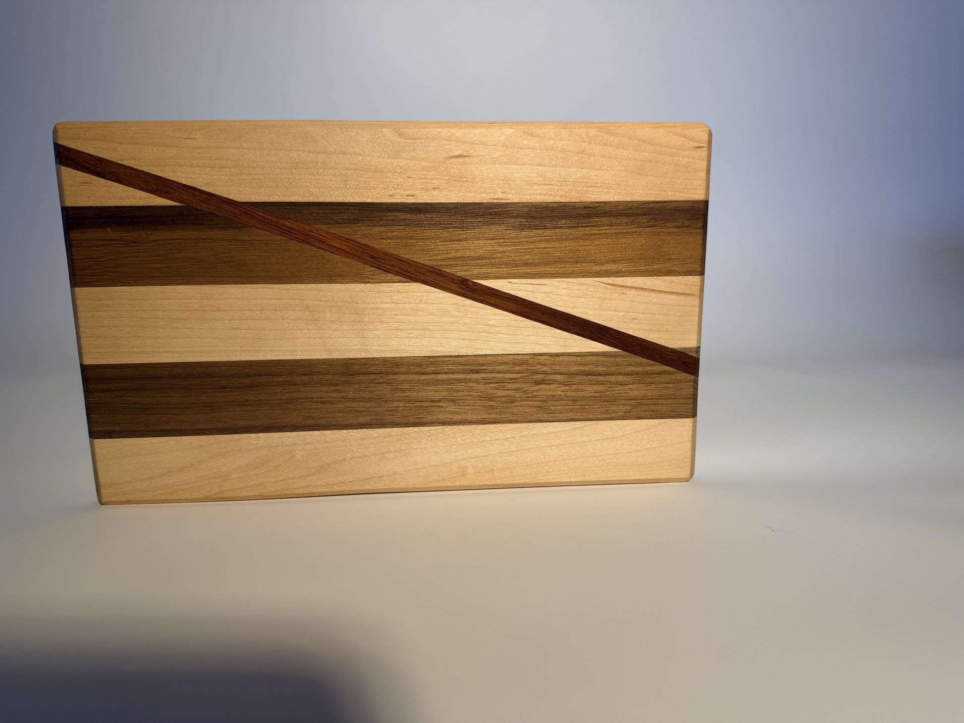 Short Cuts board angled to show maple and walnut stripes