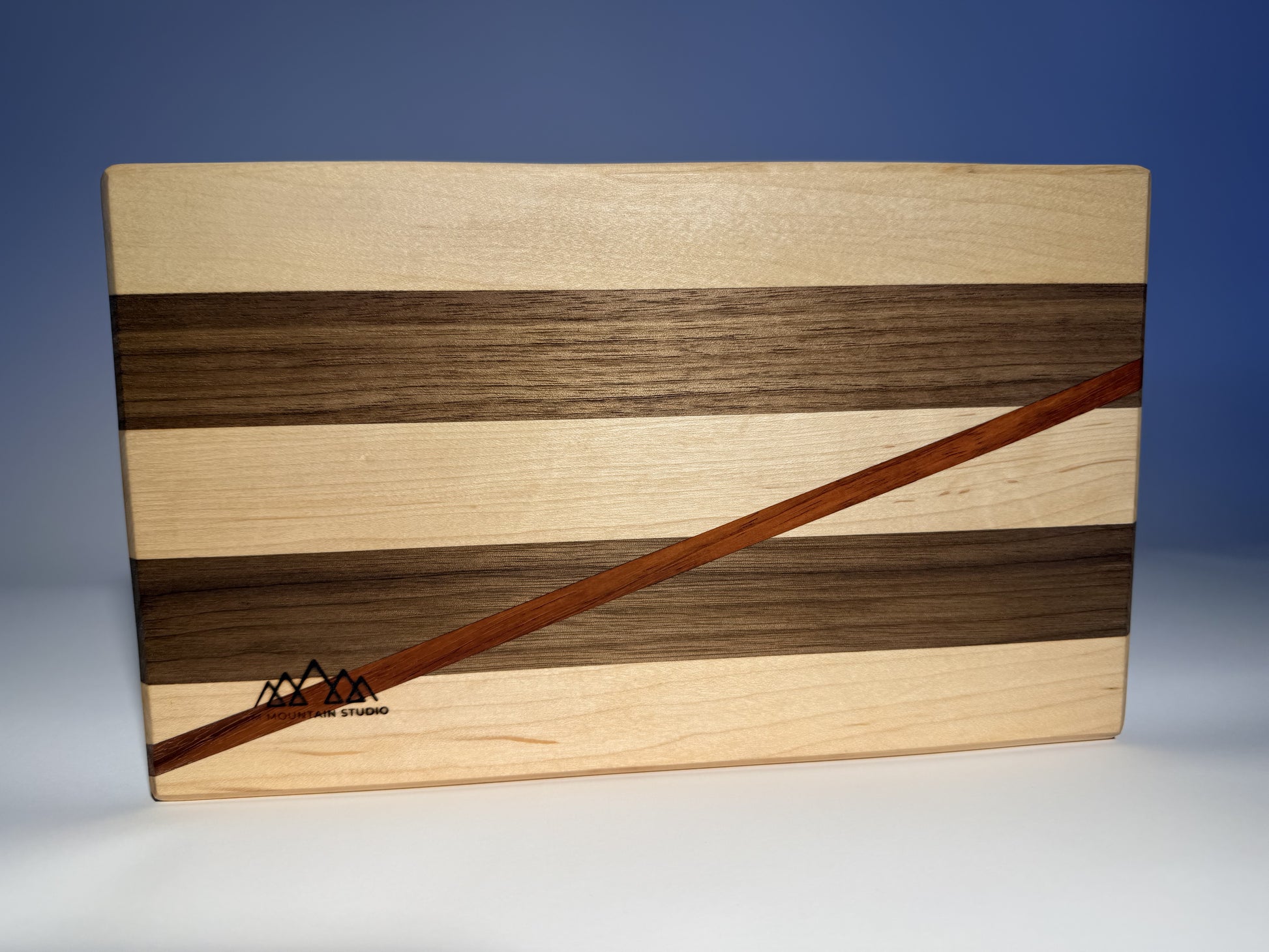 Close-up of padauk stripe and branded JMMS logo on Short Cuts board
