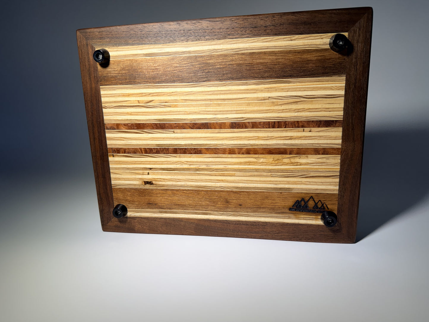 Walnut-framed cutting board — back with rubber feet and logo