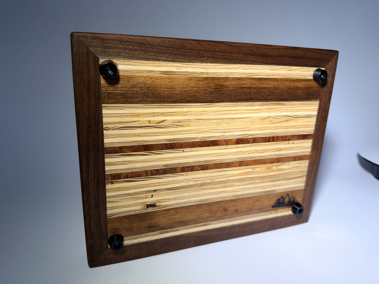 Walnut-framed cutting board — angled back view with feet