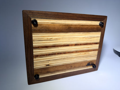 Walnut-framed cutting board — angled back view with feet