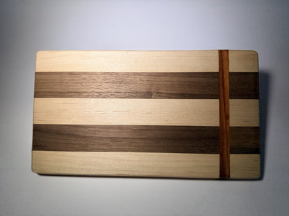 Walnut and maple striped cutting board with straight padauk line — full face view