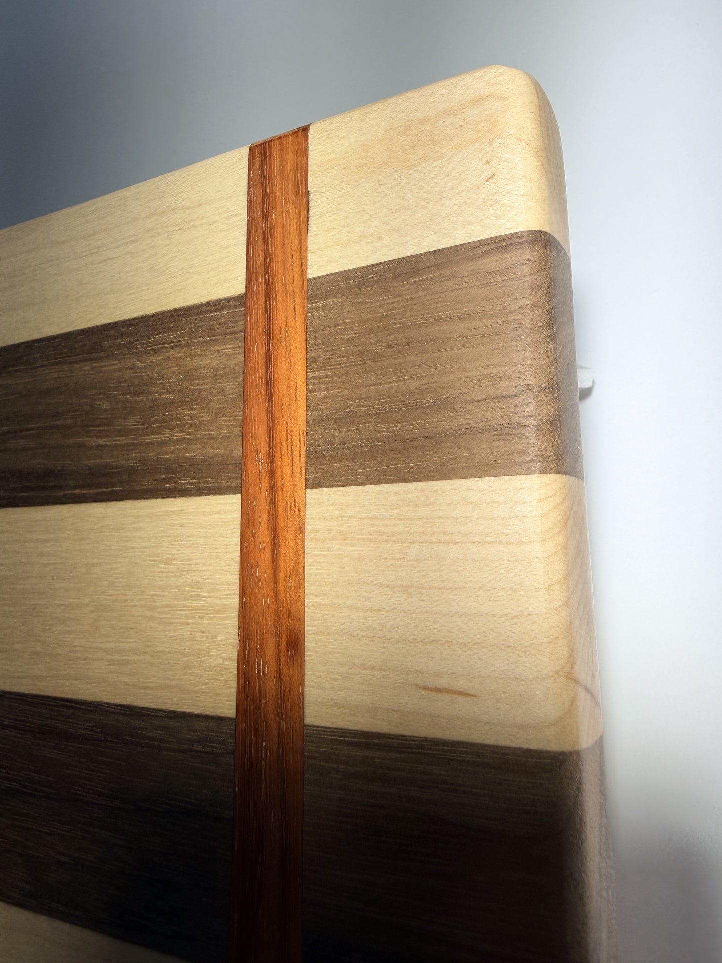 Walnut, maple, and padauk grain — edge close-up