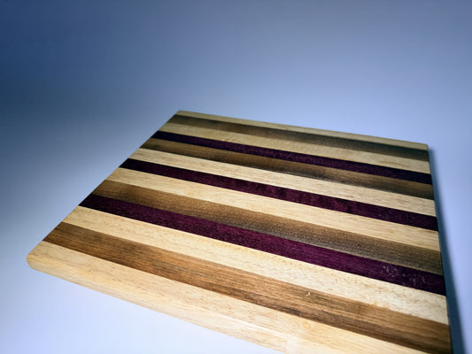 Striped cutting board with purpleheart and walnut — front three-quarter view
