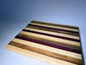Striped cutting board with purpleheart and walnut — front three-quarter view
