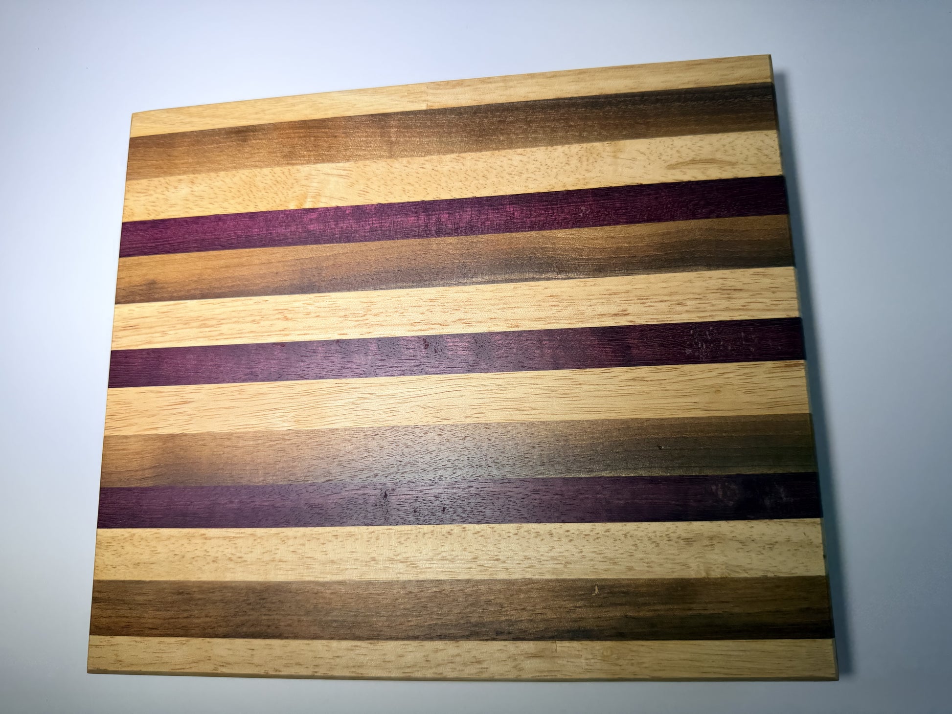 Striped cutting board with purpleheart and walnut — full face view