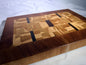 End-grain mosaic cutting board with mahogany border — front three-quarter view