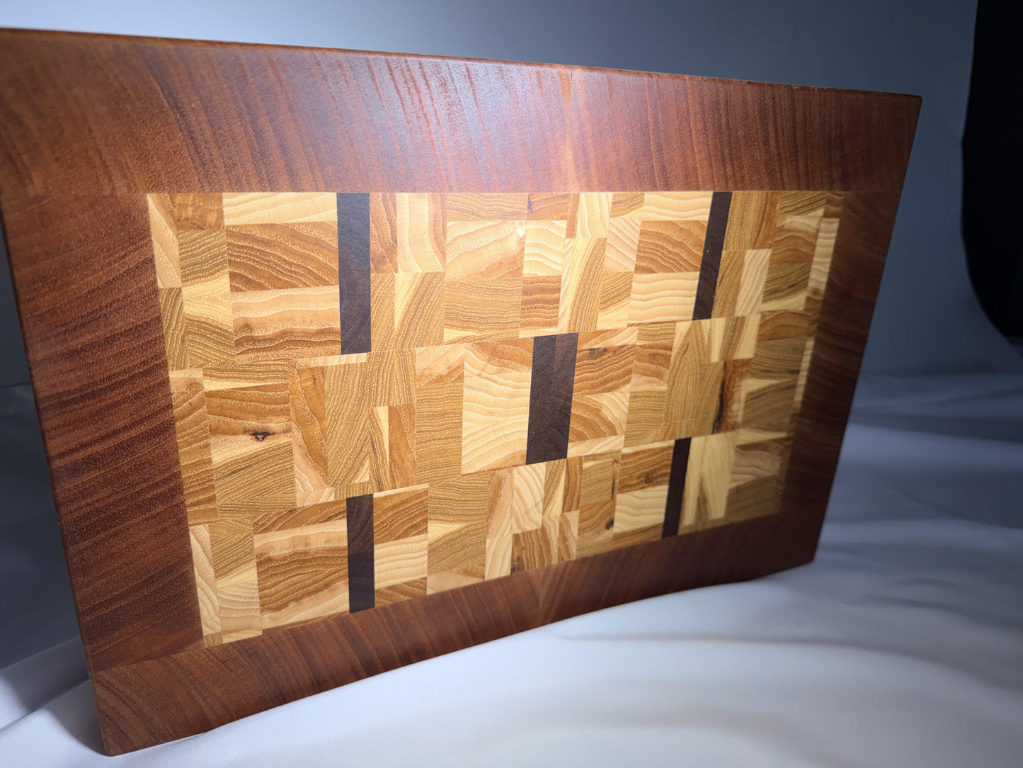 End-grain mosaic cutting board with mahogany border — angled view