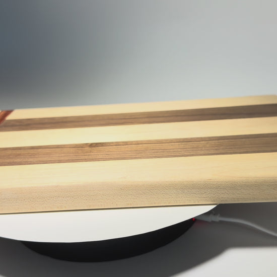 Walnut and maple cutting board with straight padauk line — rotating view