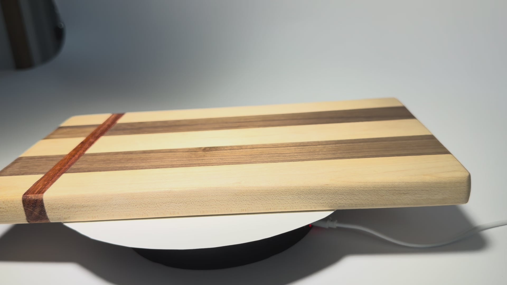 Walnut and maple cutting board with straight padauk line — rotating view