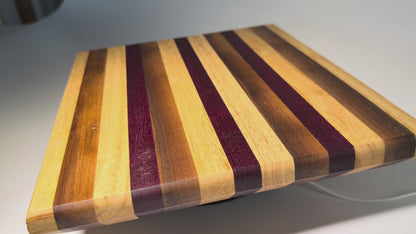 Striped cutting board with purpleheart and walnut — rotating view